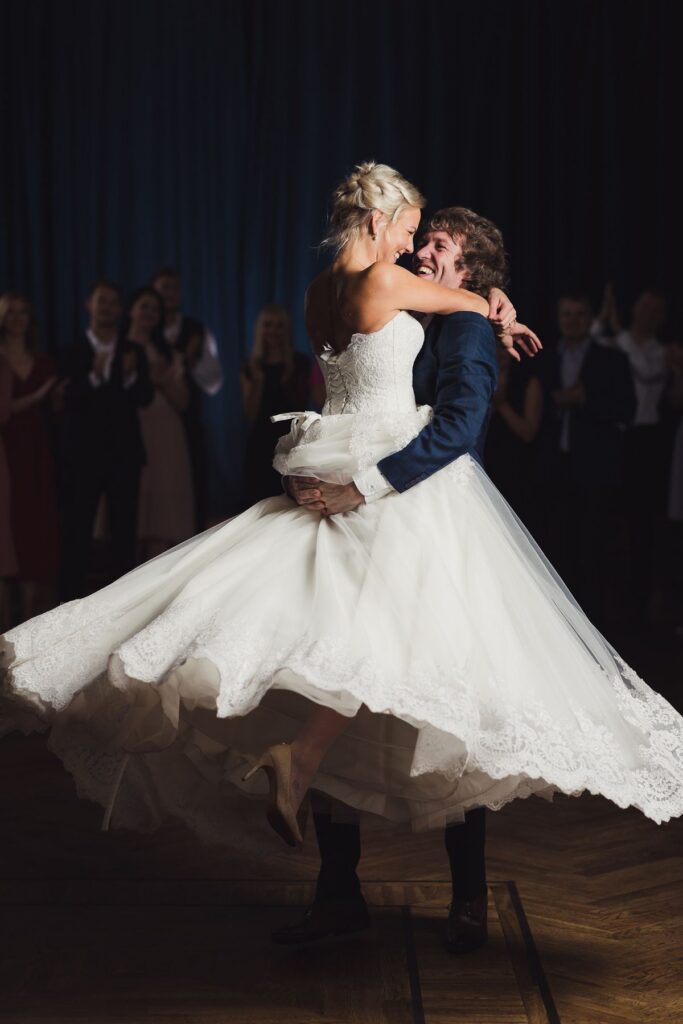 Bride and groom practicing their wedding dance in full attire during a private lesson